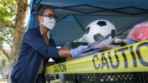 LOS ANGELES, CA – MAY 06: Renata Simril, of LA84, Foundation, distributes sports goods to under-served kids, at LAUSD Grab and Go meal center at Thomas Alva Edison School. Thomas Alva Edison Middle School on Wednesday, May 6, 2020 in Los Angeles, CA. 